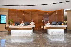 um grupo de pessoas sentadas em mesas em um lobby em Atour Hotel Luliang Central Park em Luliang