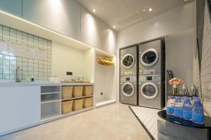 a laundry room with three washing machines and a counter at Atour Hotel Jiashan Dazhong Plaza in Jiashan