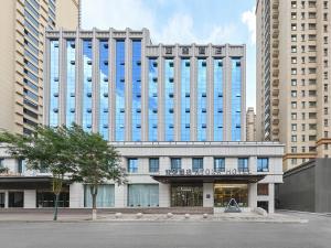 a large building with blue windows in a city at Atour Hotel Luliang Central Park in Luliang