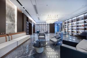 a waiting room with couches and chairs and a chandelier at Atour Hotel Anqing Municipal Affairs Center Seventh Street in Anqing