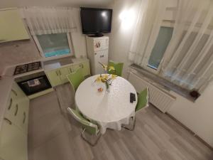 une cuisine avec une table blanche et des chaises vertes dans l'établissement APARTMENTS KRAPEC2, à Ježdovec