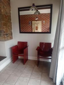 a waiting room with two red chairs and a mirror at B and B Sandton in Johannesburg