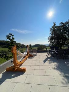 a patio with chairs and a hammock on it at Mountain Luxury Lodges in Slavetić