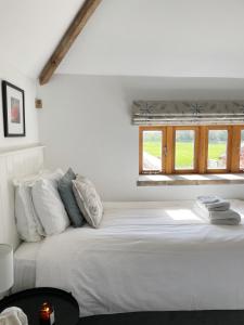 a white bed in a room with a window at The Granary, Norfolk in Norwich