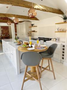 a kitchen with a wooden table and chairs at The Granary, Norfolk in Norwich