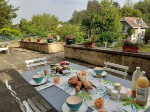 - une table avec de la nourriture sur la terrasse dans l'établissement La Fée des Eaux, à Vernaison
