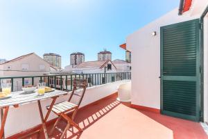a patio with a table and chairs on a balcony at Vita Portucale ! Costa Caparica Triplex w/ Terrace in Costa da Caparica