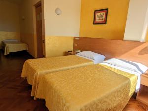 two beds in a hotel room with yellow walls at Hotel Del Sole in Sora