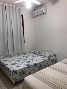 a small bedroom with two beds and a window at CASA DE TEMPORADA in Aracaju