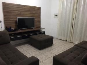 a living room with two couches and a flat screen tv at CASA DE TEMPORADA in Aracaju