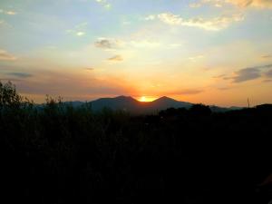 um pôr-do-sol sobre uma montanha com o pôr-do-sol em Beautiful & cosy 5-Bedroom Villa - Peloponnese em Pídhima