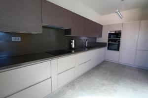 una cocina con armarios blancos y encimeras negras en Vistaport A - Luxury Villa, en Bodrum City