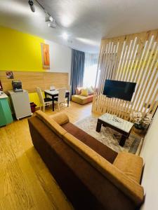 a living room with a couch and a dining room at Colombia Apartments&Rooms in Durrës
