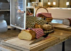 a table with a cutting board with bread and a knife at Edelweiss Lodge in Wilderswil