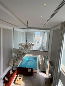 un soggiorno con piscina e lampadario pendente di شاليه كادي cady resort a Al Khobar