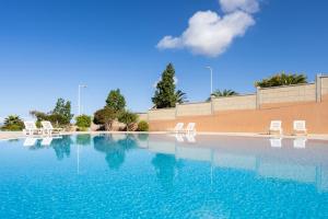 een zwembad met stoelen en blauw water bij Nice Garden Valle del Sol in Adeje