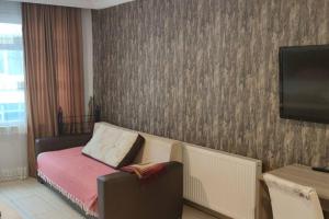 Habitación pequeña con cama y TV. en Midtown Hotel Apartments 202(0+1), en Estambul