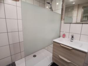 ein weißes Badezimmer mit Waschbecken und Dusche in der Unterkunft Ferienwohnung am Bach in Mörlenbach