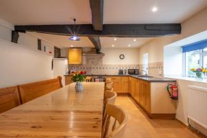 a large kitchen with a wooden table and chairs at Little Cowarne Court in Little Cowarne