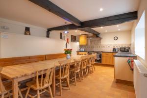 a kitchen with a long wooden table and chairs at Little Cowarne Court in Little Cowarne