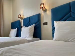 2 camas con cabeceras azules en una habitación de hotel en Astoria, en Casablanca