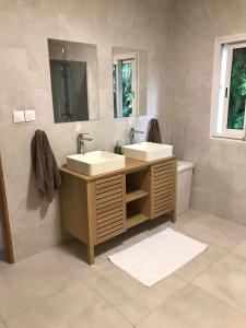 Baño con 2 lavabos y espejo en Villa Horizon, en Saint-Joseph