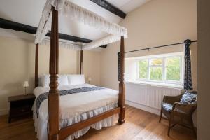 a bedroom with a canopy bed and a window at Little Cowarne Court in Little Cowarne