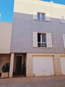 a building with two windows and a door at Magnifico chalet adosado en Torrevieja, Alicante. in Torrevieja