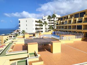 a view of a building with a tennis court on the roof at Sunset Arena Beach by HelloApartments in Puerto de Santiago