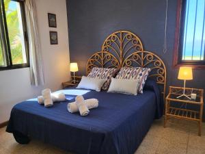 a bedroom with a blue bed with towels on it at Sunset Arena Beach by HelloApartments in Puerto de Santiago +34 photos