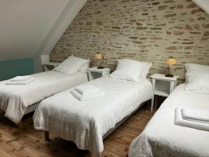 twee bedden in een kamer met twee lampen op tafels bij LA VELOGIROUETTE in Feuguerolles-sur-Orne