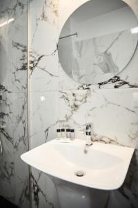 y baño con lavabo blanco y espejo. en Astra Hotel en Călimăneşti