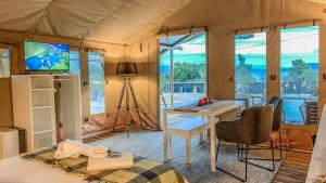 Una habitación con una cama y un escritorio en una tienda de campaña en African Safari Canvas Lodge Tent Sea View, en Kranidi