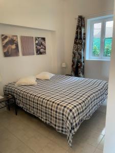 um quarto com uma cama com um cobertor xadrez em Moinho Da Asneira - Duna Parque Group em Vila Nova de Milfontes
