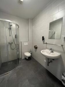 a bathroom with a shower and a sink and a toilet at Heart of Amsterdam Hotel in Amsterdam