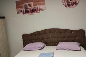 un letto con 2 cuscini viola e una testiera marrone di Midtown Hotel Apartments 201 (2+1) a Istanbul