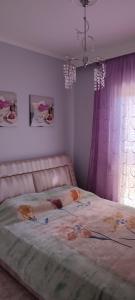 - une chambre avec un grand lit et des rideaux violets dans l'établissement Maria's home, à Órmos