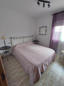 - une chambre avec un lit doté d'un couvre-lit rose dans l'établissement Migjorn 6, à Deltebre