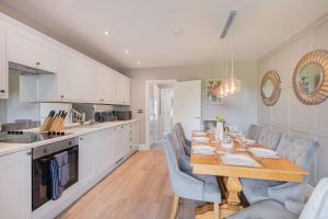 una cucina e una sala da pranzo con tavolo e sedie di Belsfield Cottage a Bowness-on-Windermere