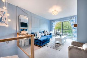a blue living room with a blue couch and a mirror at Belsfield Cottage in Bowness-on-Windermere