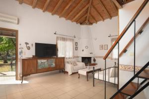 een woonkamer met een bank en een open haard bij Eleni's Cottage, for Natural Living, By ThinkVilla in Punta