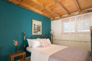 1 dormitorio con cama y pared azul en Eleni's Cottage, for Natural Living, By ThinkVilla, en Punta