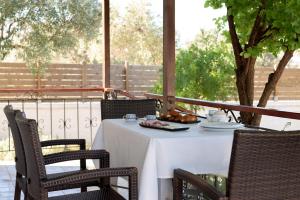 una mesa al aire libre con un mantel blanco y sillas en Eleni's Cottage, for Natural Living, By ThinkVilla en Punta