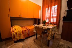 a bedroom with a table and a bed with orange cabinets at Sole Luna B&B in Pescara