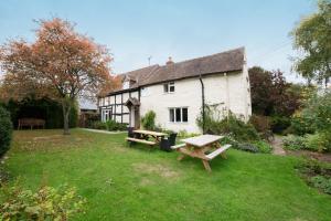a white house with a picnic table in the yard at Little Cowarne Court in Little Cowarne