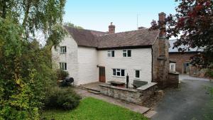 a large white house with a stone yard at Little Cowarne Court in Little Cowarne +18 photos