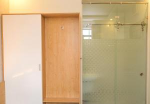 um chuveiro com uma porta de vidro na casa de banho em Lộc Thiên Ân hotel em Bien Hoa