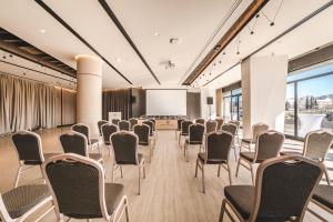 a conference room with chairs and a projection screen at Hotel Podgorica in Podgorica