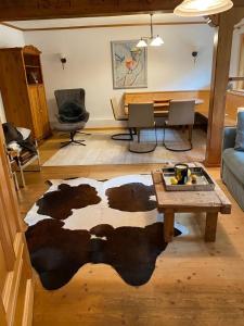 a living room with a cow rug on the floor at Frein Chalets - Kaltenbach in Frein