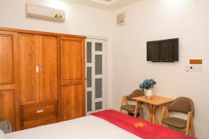 a bedroom with a bed and a tv and a table at Lộc Thiên Ân hotel in Bien Hoa